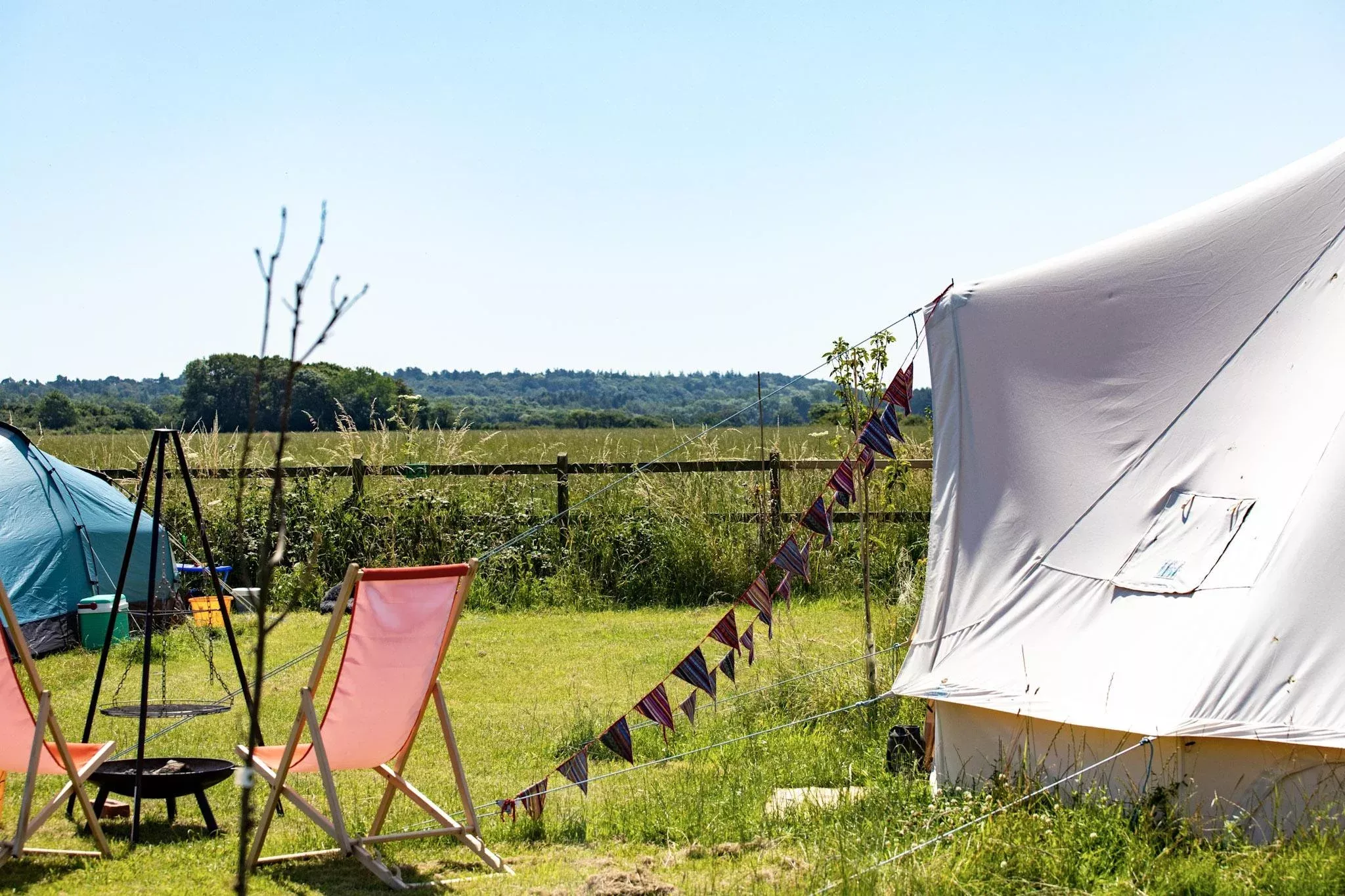 Stunning meadow view from a bell tent with a fire and seating