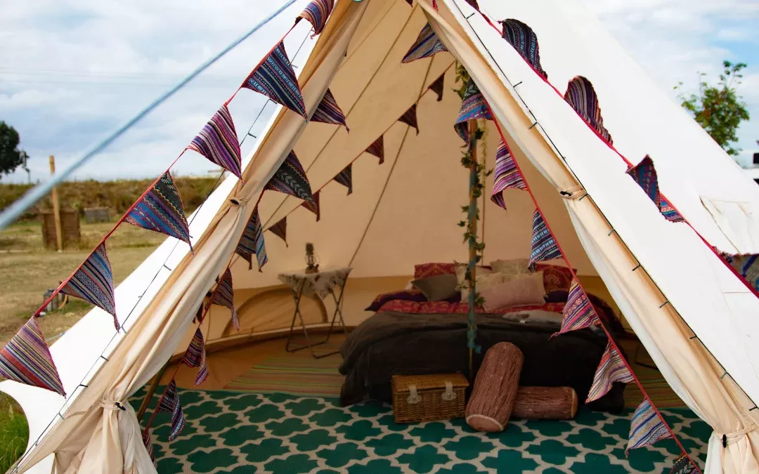 inside a bell tent with a bed and other furnishings