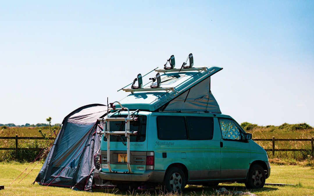 campervan with awning in field