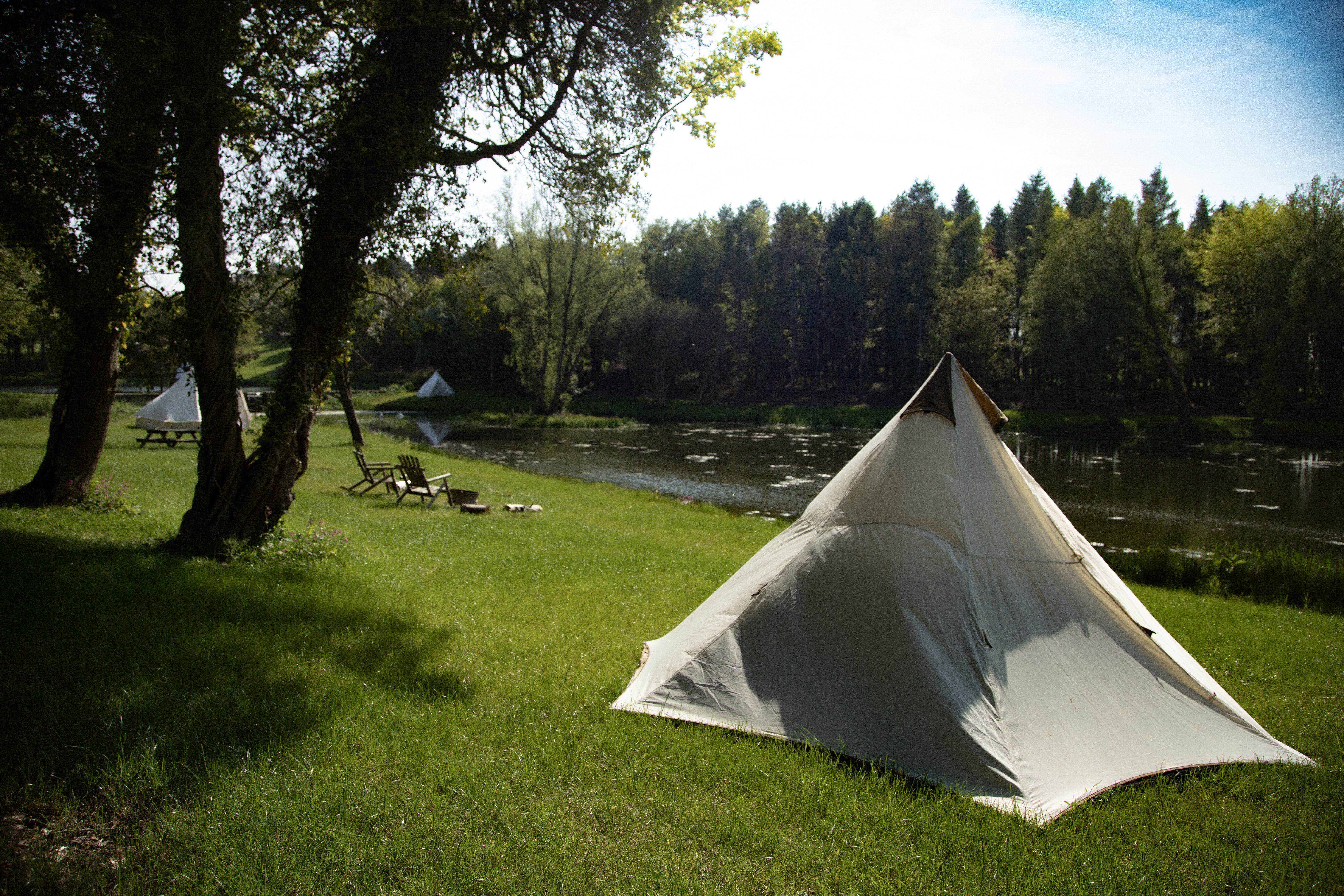 A bell tent with an outdoor bbq, firepit and plenty of green space