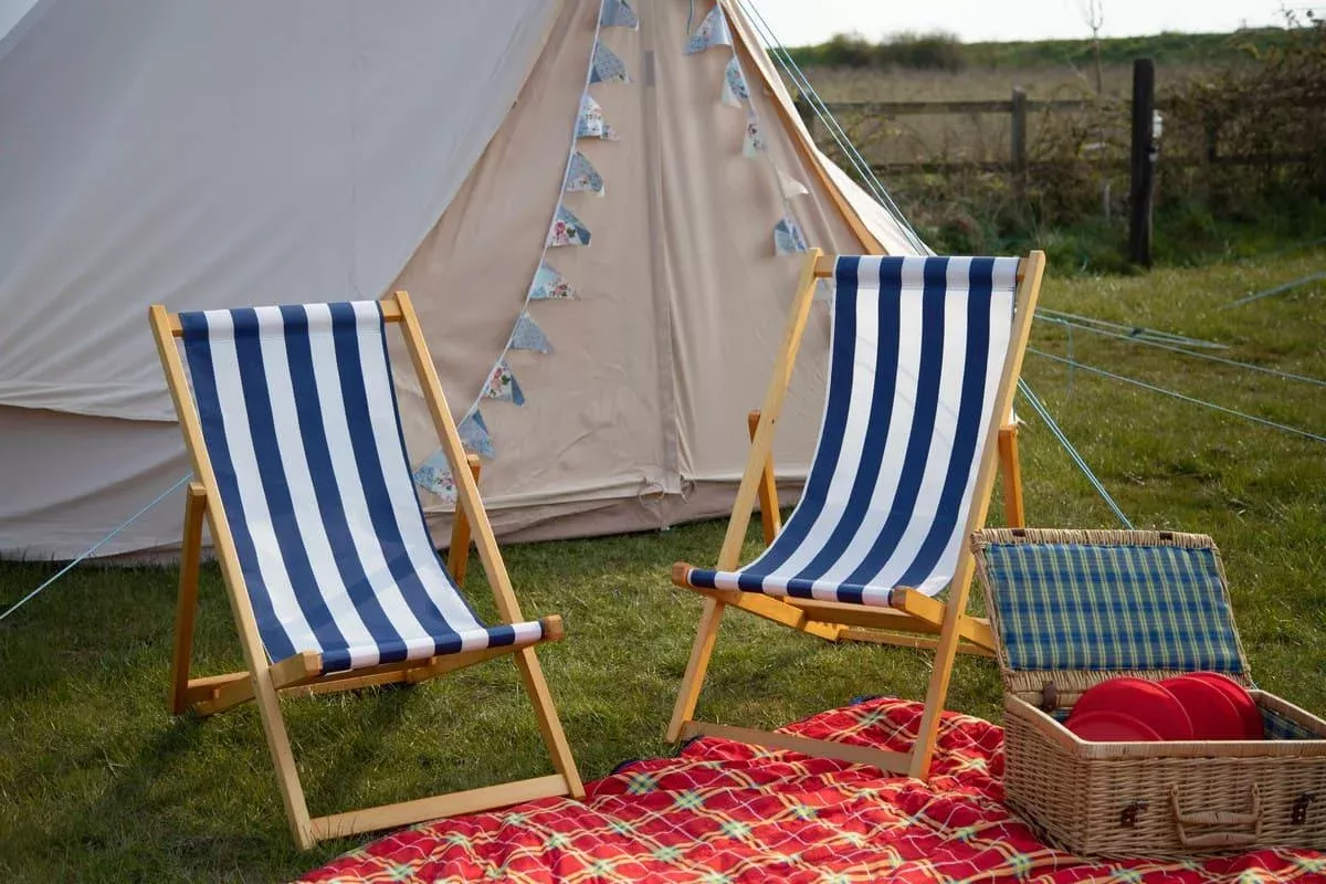 two deck chairs with a picnic setup outside of a hunstanton bell tent