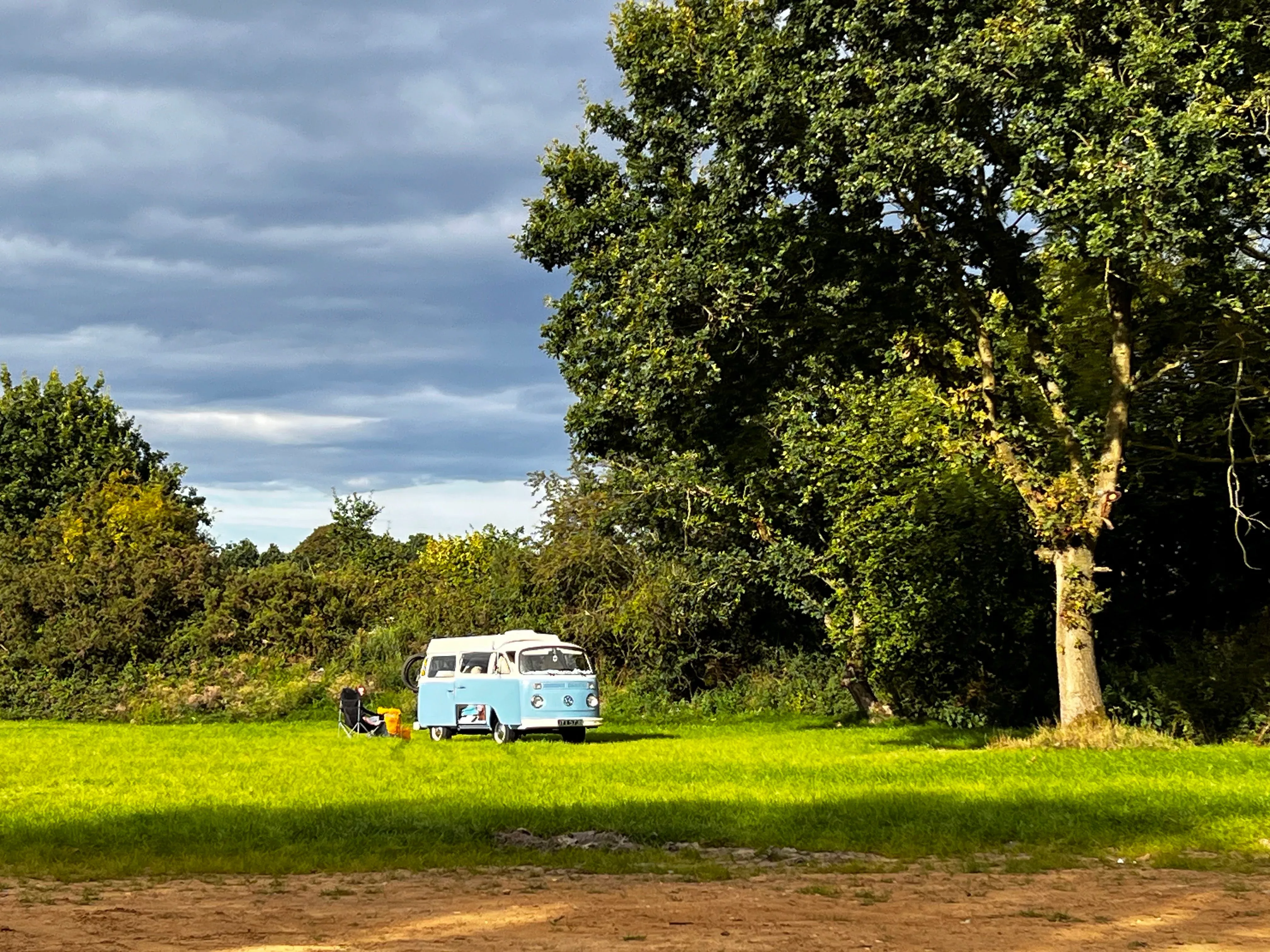 an orange vw campervan with eyes and an awning