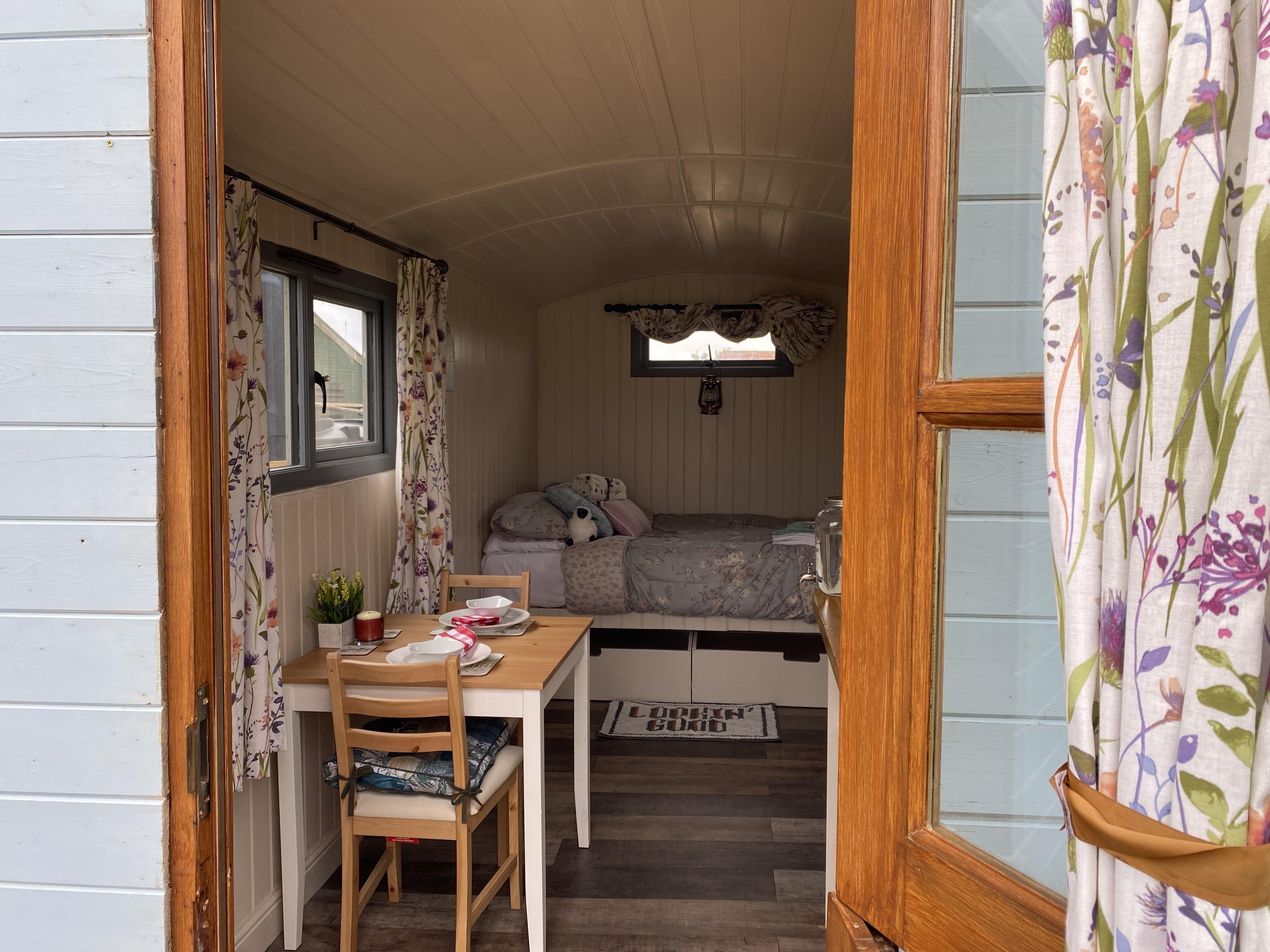 open shepherds hut with double bed in view